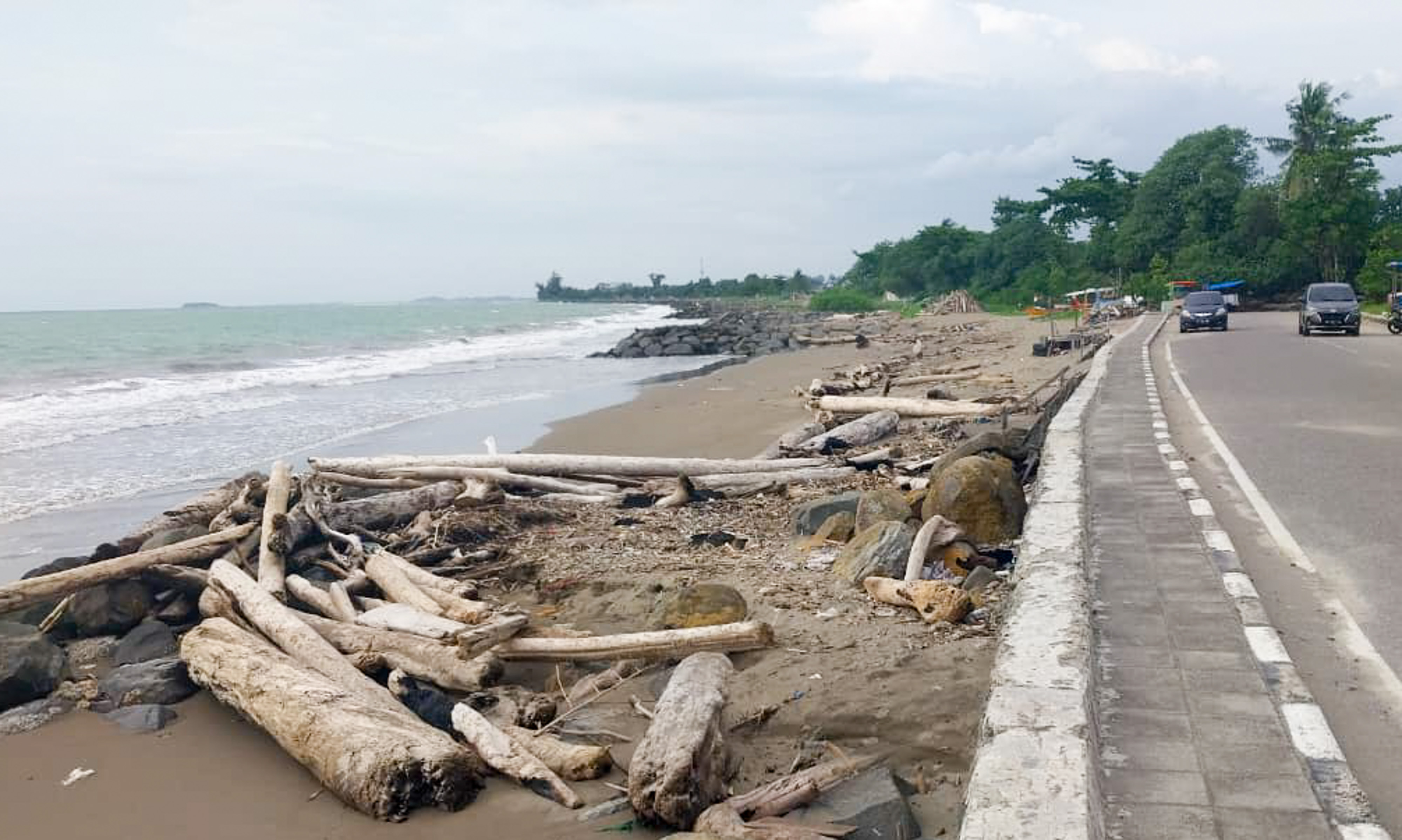 Pantai belakang Pangeran Beach Hotel Padang masih dipenuhi kayu sisa banjir yang terjadi November 2025 lalu.