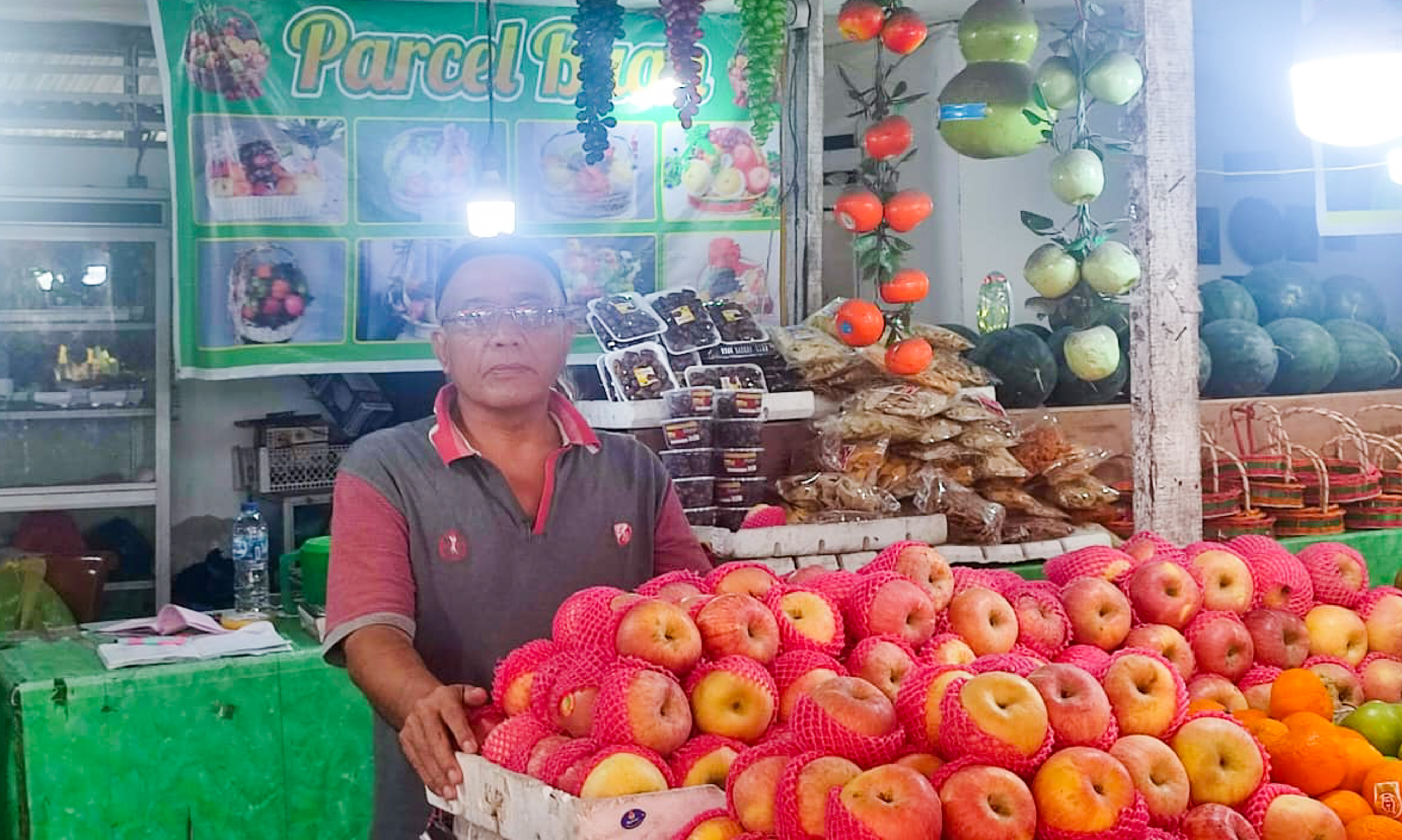 Asrial (55), pemilik Toko Buah Alam Sari di Pasar Buah Lubuk Buaya, Kota Padang. (f: riyadhatul/padeks)