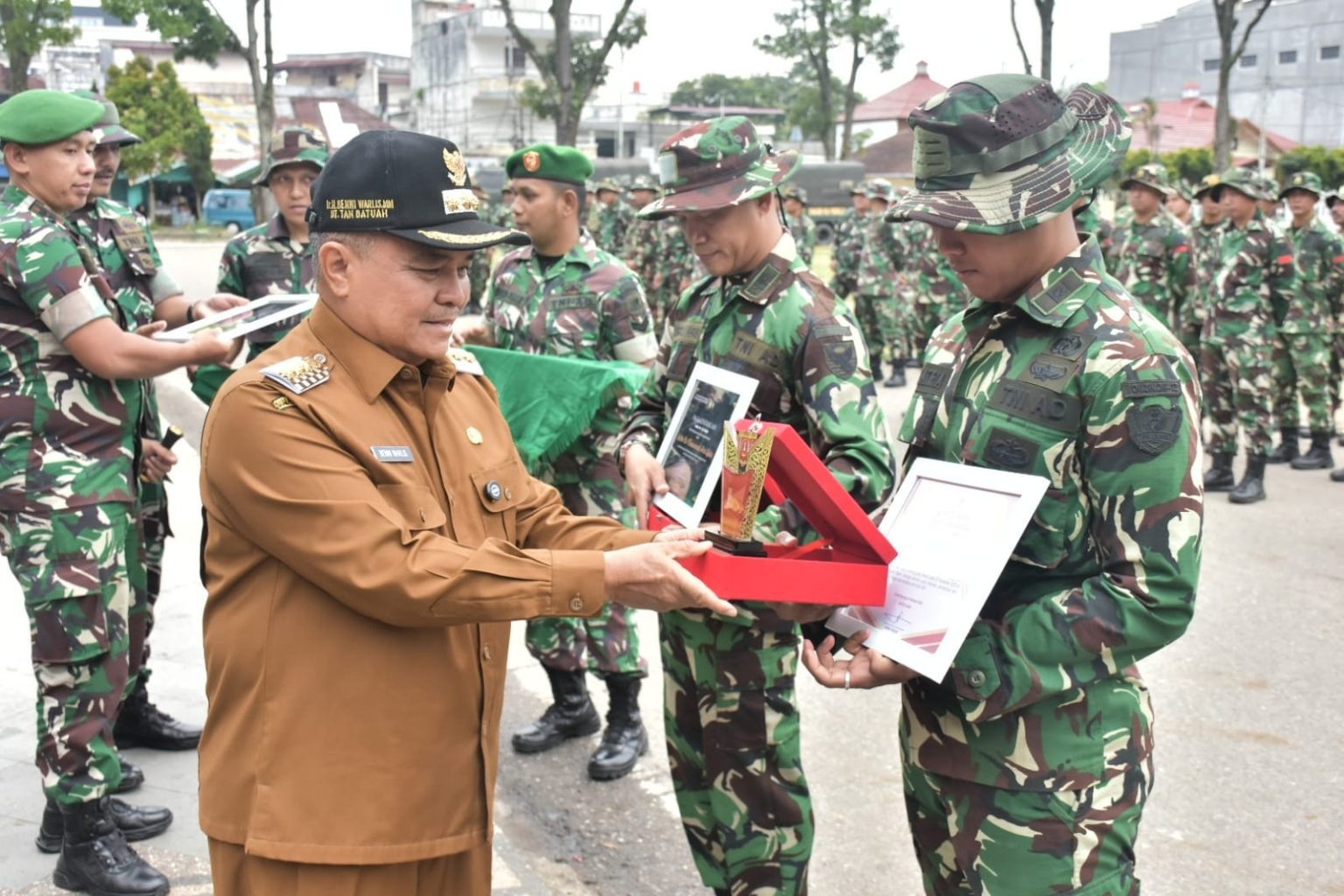 Bupati Agam Benni Warlis menyerahkan cenderamata kepada perwakilan personel Satgas Zeni BKO Gulbencal Sumbar saat upacara pelepasan di lapangan Makodim 0304/Agam, Selasa (24/2).