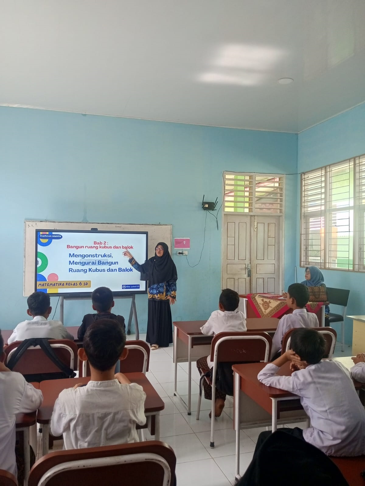 BELAJAR : Guru SDN 31 Payakumbuh memberikan materi pembelajaran kepada murid.