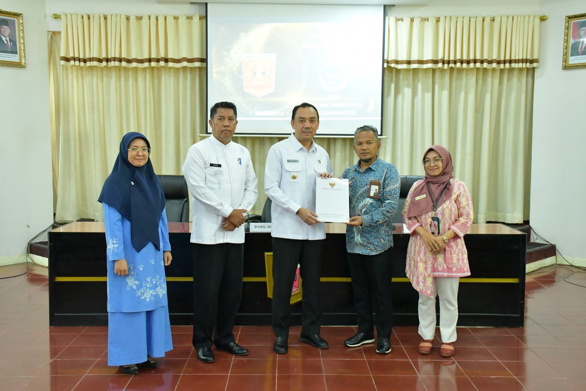 Kepala Perwakilan Ombudsman Sumbar Adel Wahidi menyerahkan hasil Penilaian Penyelenggaraan Pelayanan Publik Tahun 2025 kepada Wakil Bupati Agam Muhammad Iqbal di Aula Kantor Bupati Agam, Kamis (26/2).