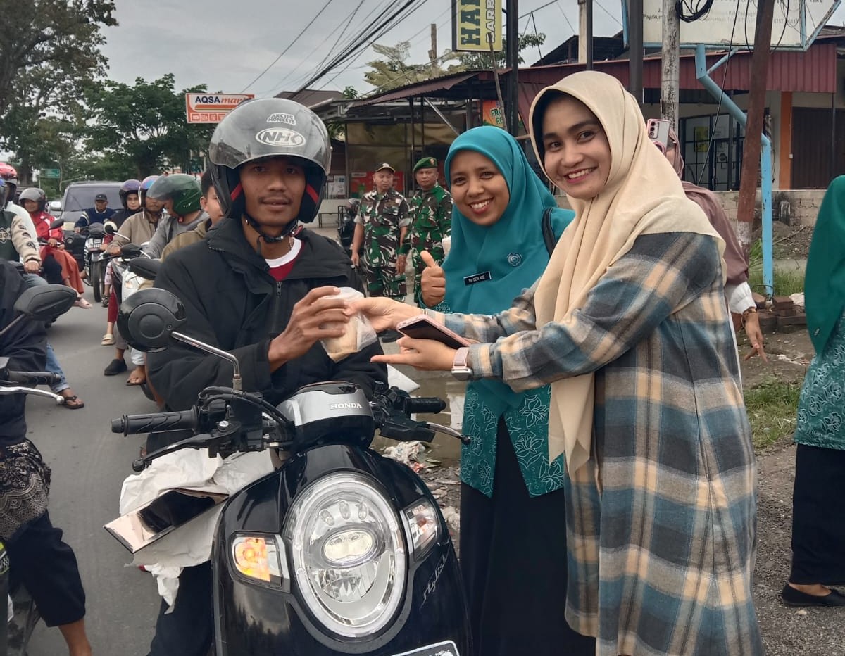 ASN dan PKK Payakumbuh Selatan membagikan takjil gratis kepada pengendara di SPBU Sawah Padang saat Ramadan 1447 H.