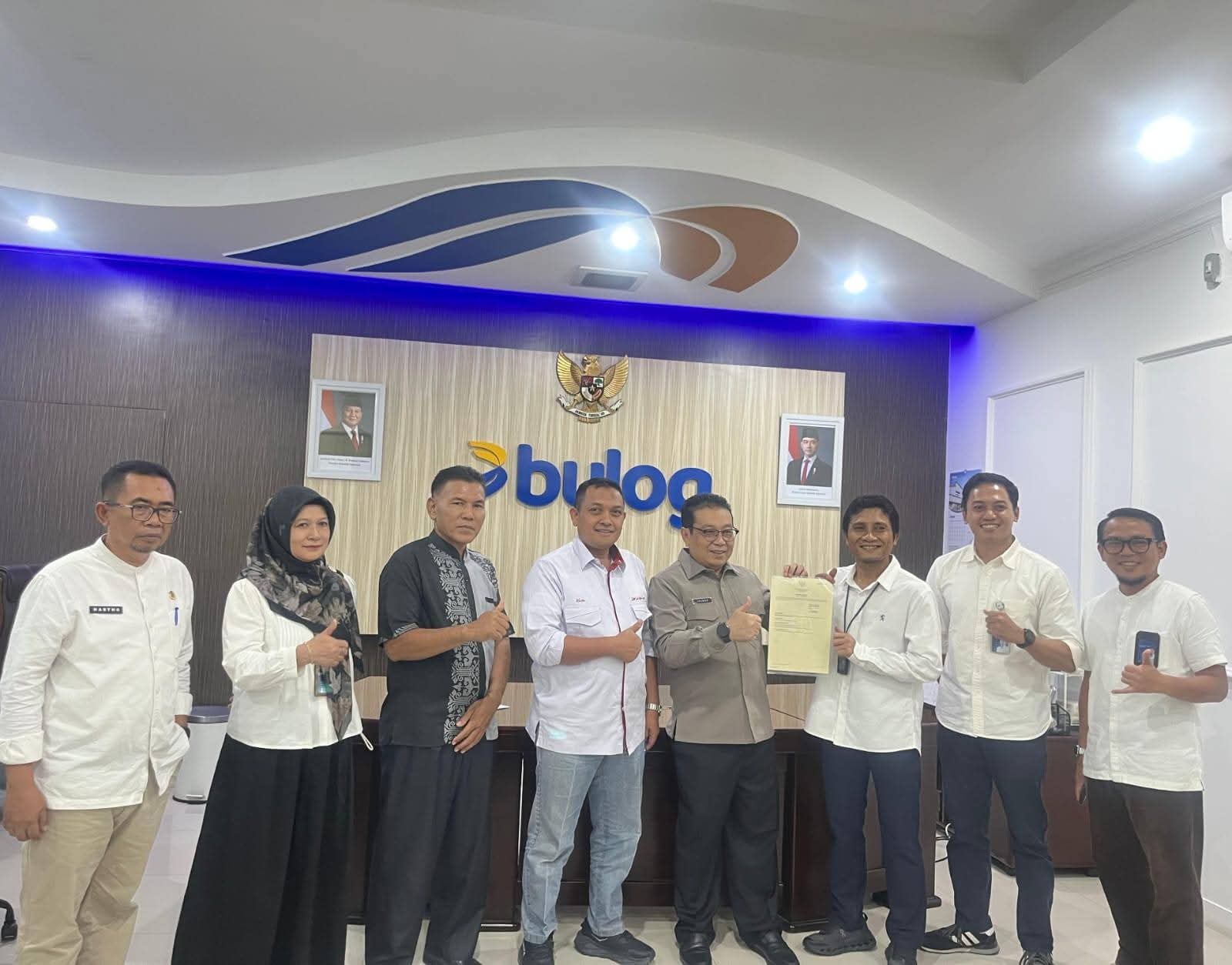 Pj  Sekdakab Dharmasraya Jasman berfoto bersama usai menandatangani NPHD pendirian gudang Bulog di Dharmasraya.