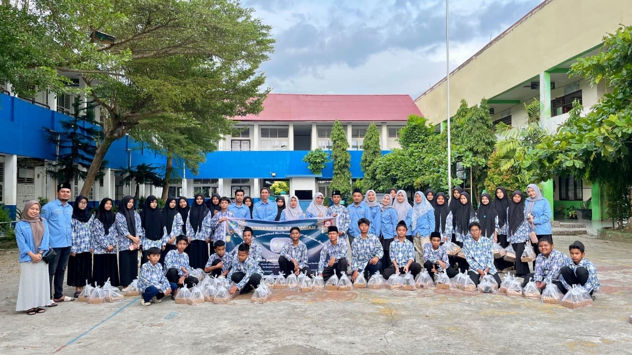 BERBAGI : Sisiwa SMPN 13 Padang berfoto bersama sebelum berbagi takjil dengan para pengendara yang melintasi jalan raya di Tabing.(Tim laman guru)