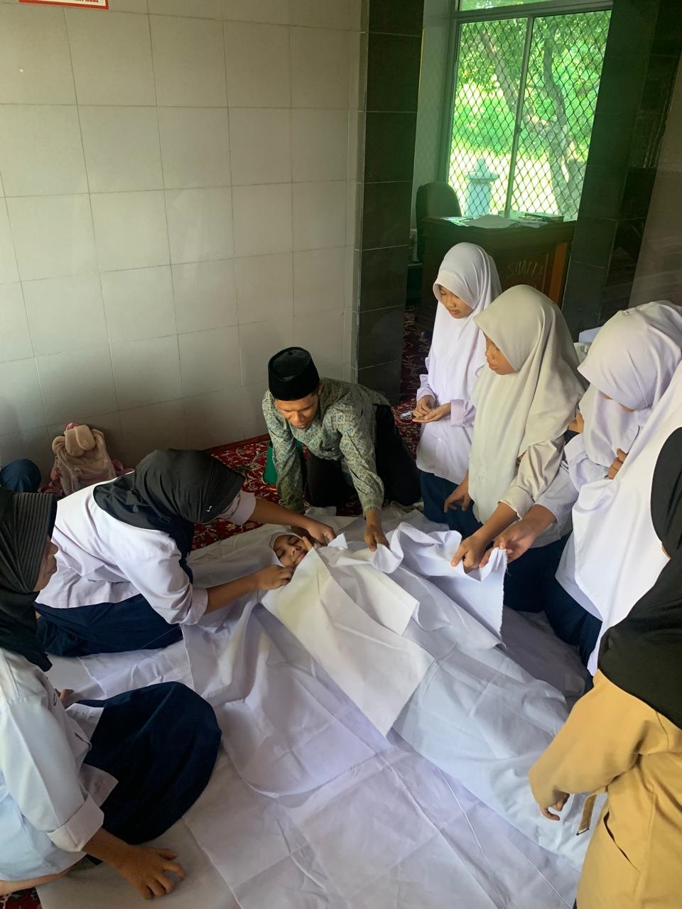 PRAKTIK: Siswa SMPN 30 Padang saat melakukan praktik penyelenggaraan jenazah di Musala Sakinah.(Tim laman guru)