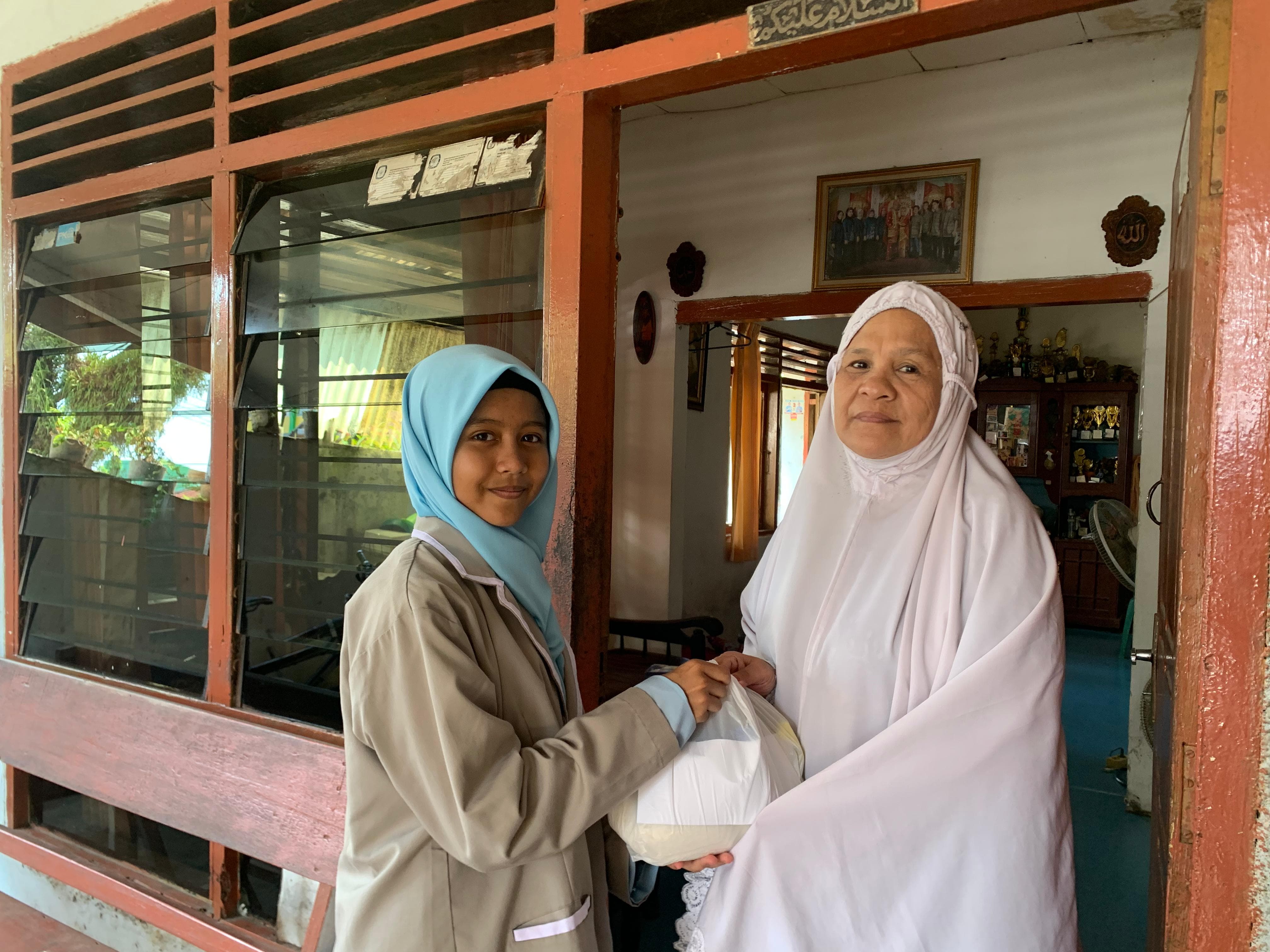 Ketua OSIS SMPN 2 Pariaman, Hafidzah Zhafira Indra, serahkan sembako untuk warga.
