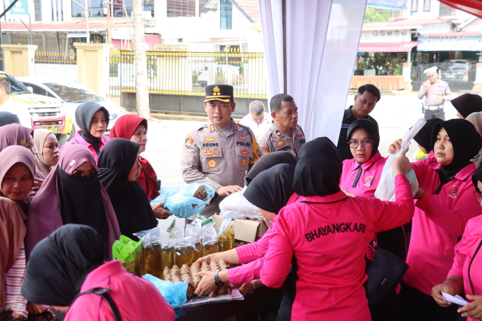 Warga membeli kebutuhan pokok dalam kegiatan pasar murah di halaman Mapolres setempat, Sabtu (14/3). 