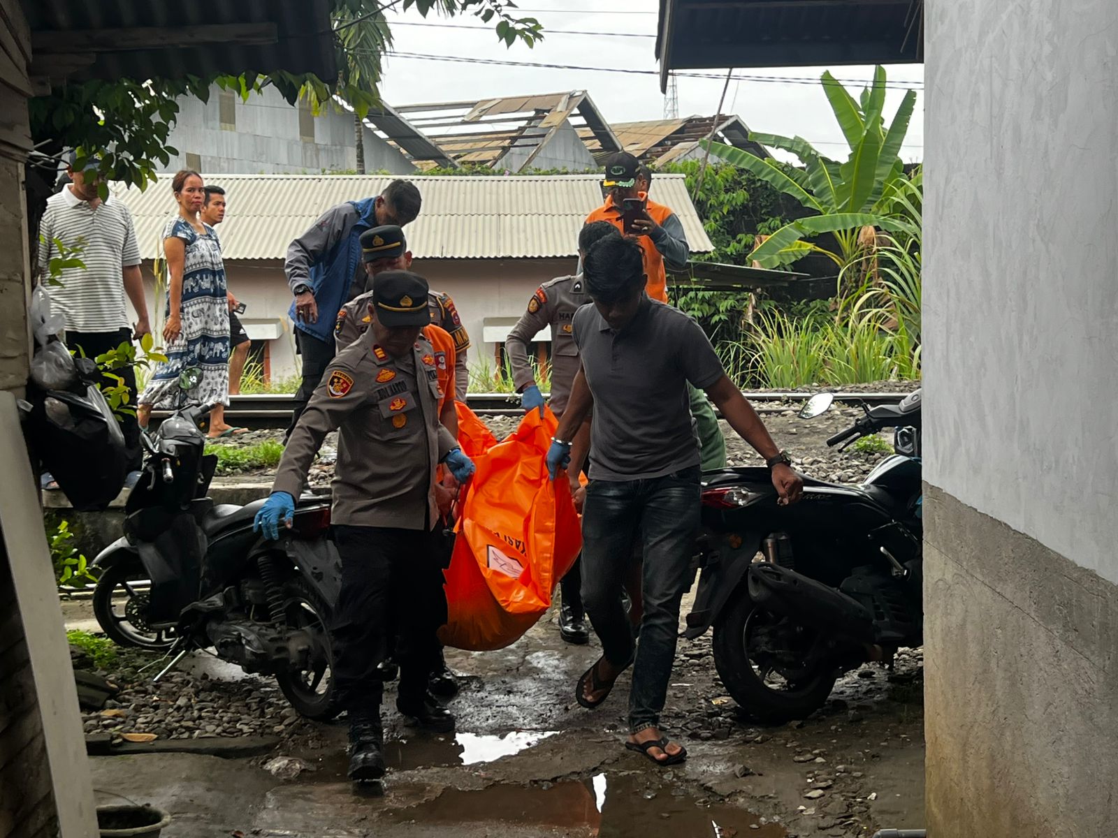 Petugas kepolisian melakukan evakuasi mayat pria 50 tahun yang ditemukan di rel kereta api Pauh, Padang, Rabu pagi (25/3/2026).