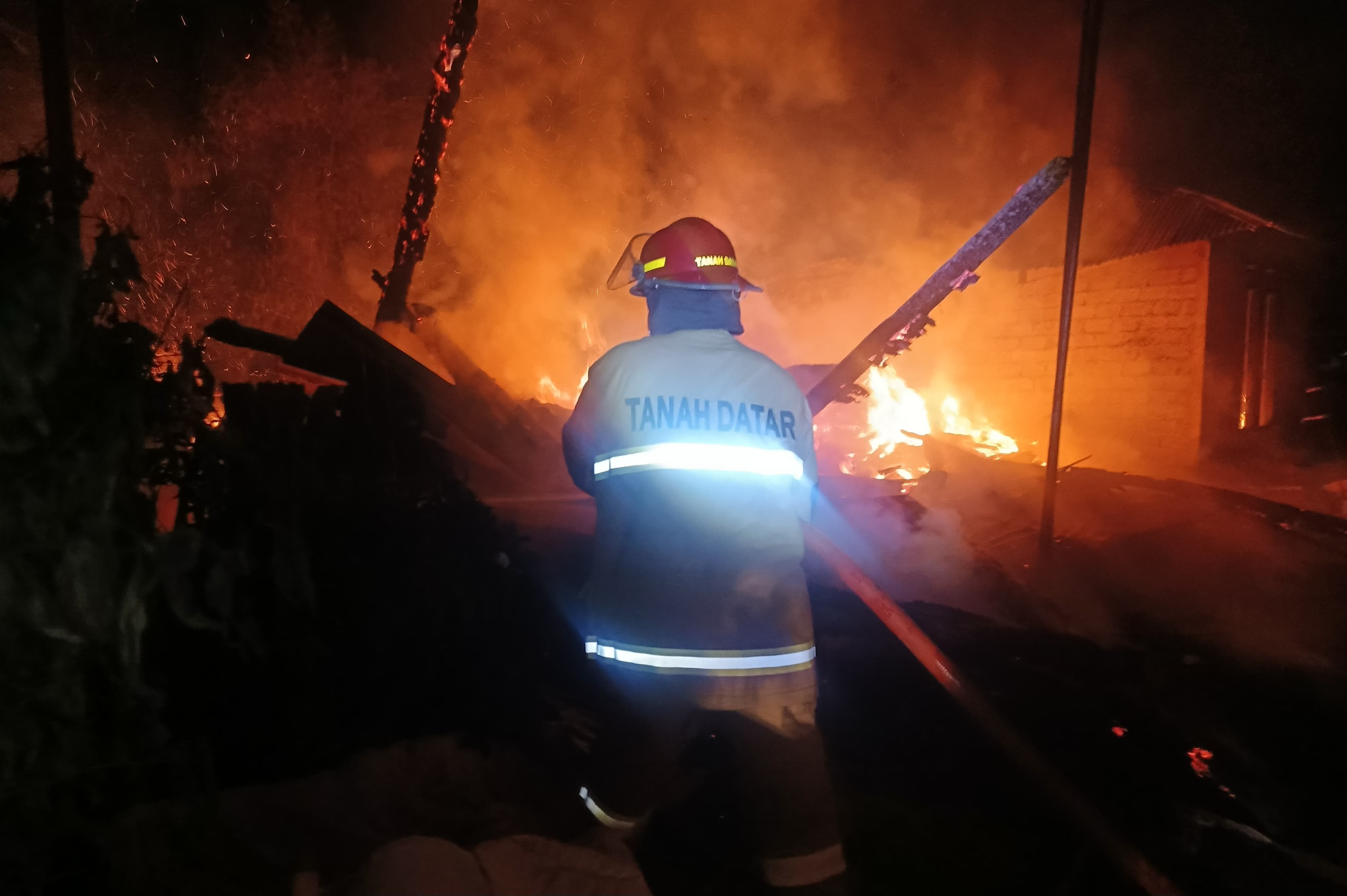 Personel Damkar Tanahdatar memadamkan kebakaran dua rumah di Nagari Sumaniak, Rabu (25/3), dengan 17 personel dan tiga armada untuk mencegah api meluas.