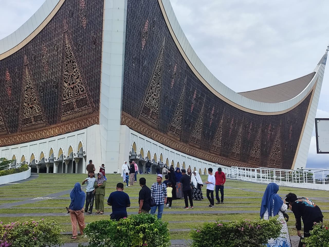 Wisatawan saat berfoto dengan latar belakang Masjid Raya Syekh Ahmad Khatib Al-Minangkabawi, Rabu (25/3).
