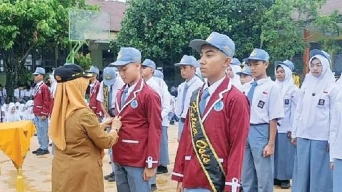 SERAH TERIMA OSIS: Kepala SMAN 9 Padang, Dra. Enny Sasmita, M.Pd saat menghadiri serah terima
OSIS 2025-2026 di halaman SMAN 9 Padang beberapa waktu lalu. (TIM LAMAN GURU)