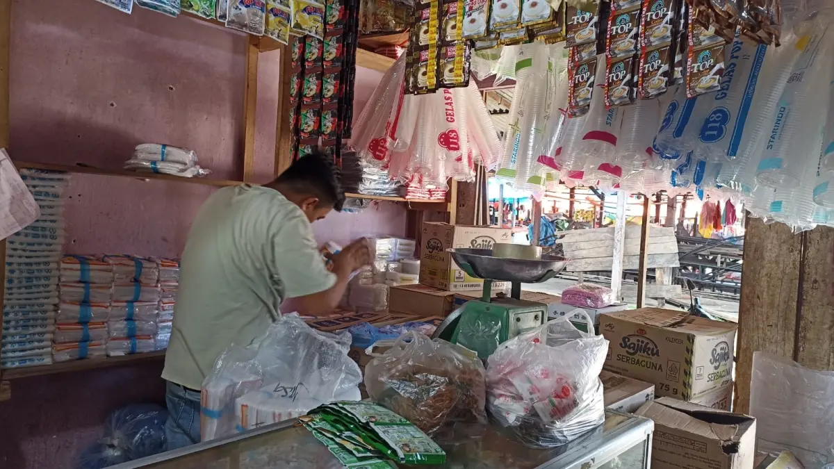 NAIK: Seorang pedagang plastik menyusun barang dagangan di Simpang Empat, Rabu (8/4).