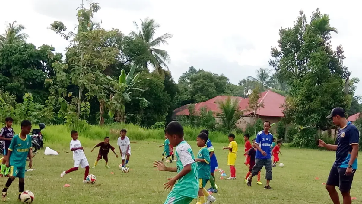 Ardian Adi Tores dan Patrianto sedang mengajarkan passing kepada anak-anak  Sekolah Sepak Bola (SSB) Parak Jariang (Persepaja) 06, Sabtu ( 11/4)  di lapangan Parak Jariang, Koronggadang, Kuranji. (JUFRI JAO/PADEK)