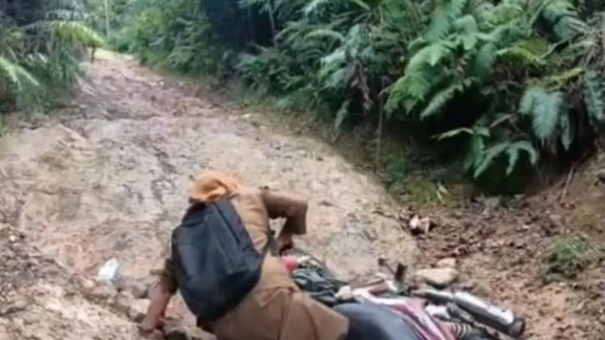 Perjuangan seorang guru saat melintasi jalan rusak di Jorong Nenan, Nagari Maek, Kecamatan Bukit Barisan, Kabupaten Limapuluh Kota, beberapa waktu lalu.
