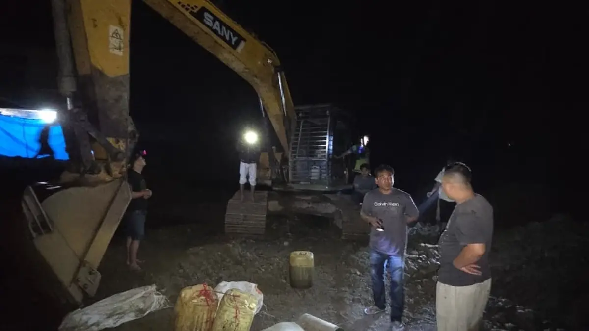 Petugas kepolisian menunjukkan alat berat ekskavator yang disita saat penertiban tambang emas ilegal di Batang Air Sibinail, Rao Selatan, Pasaman, Senin malam (13/4). (POLRES PASAMAN FOR PADEK)
