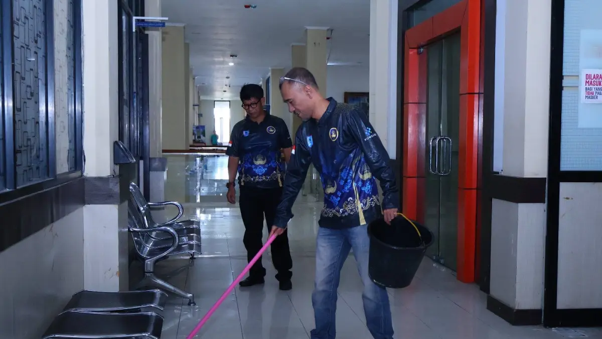 Pegawai Diskominfo Payakumbuh melakukan kerja bakti di lingkungan kantor sebagai bentuk implementasi Gerakan Nasional Indonesia ASRI, Jumat (17/4). (DOK MC PAYAKUMBUH)