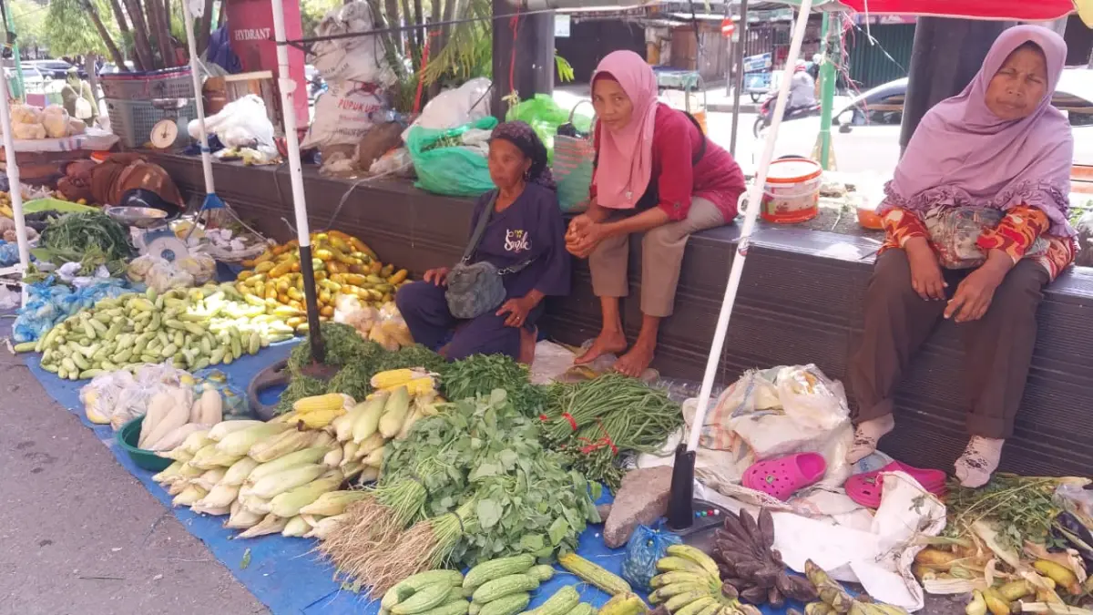 Tiga pedagang sayur di kawasan Pasar Raya Padang yang sepi sedang menunggu pembeli, Minggu (19/4/2026) siang. (Foto: Mengki Kurniawan/Padeks)