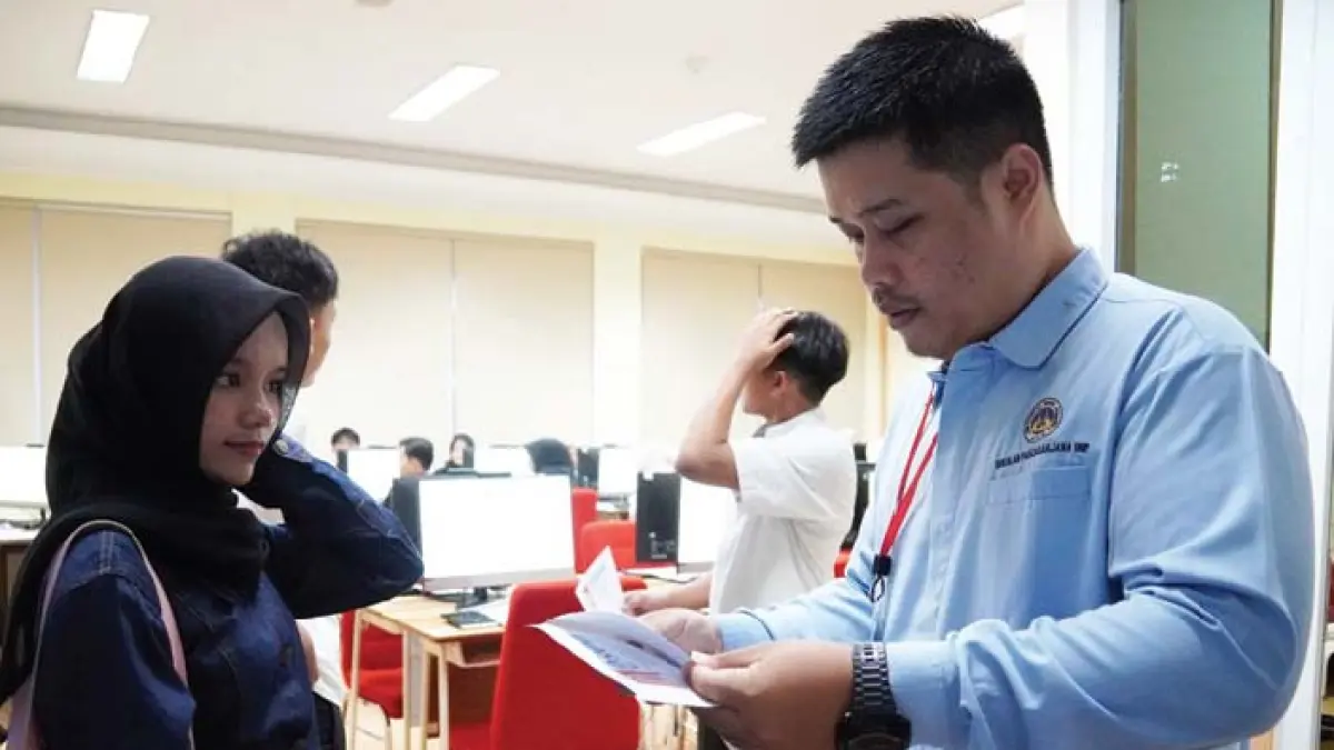 Pengawas UTBK di Universitas Negeri Padang memeriksa kelengkapan identitas salah seorang peserta pada hari pertama ujian, kemarin. Tahun ini UNP menampung sebanyak 18.367 peserta yang akan mengikuti ujian selama enam hari 21-26 April 2026 pelaksanaan dengan total 12 sesi. (DOK HUMAS UNP)