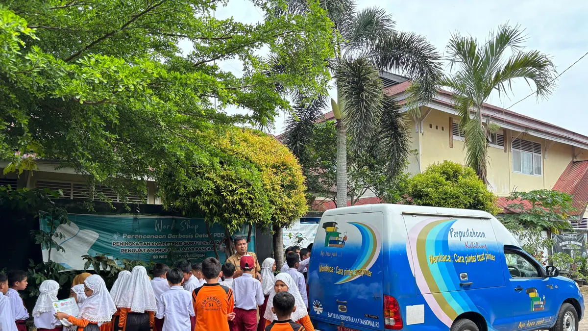 Mobil pustaka keliling  saat melayani murid SDN 31 Payakumbuh yang ingin membaca buku di halaman sekolah beberapa waktu lalu. ( foto bawah) seorang guru melayani murid yang ingin meminjam buku pada pustaka keliling. (TIM LAMAN GURU)