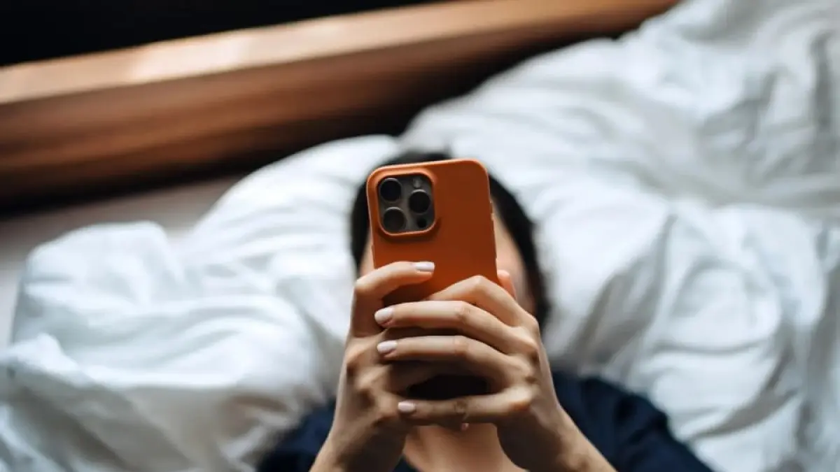 Remaja berdiam lama di tempat tidur sambil bermain gawai, menggambarkan fenomena bed rotting yang semakin marak di kalangan anak muda.(Foto: Tyla)