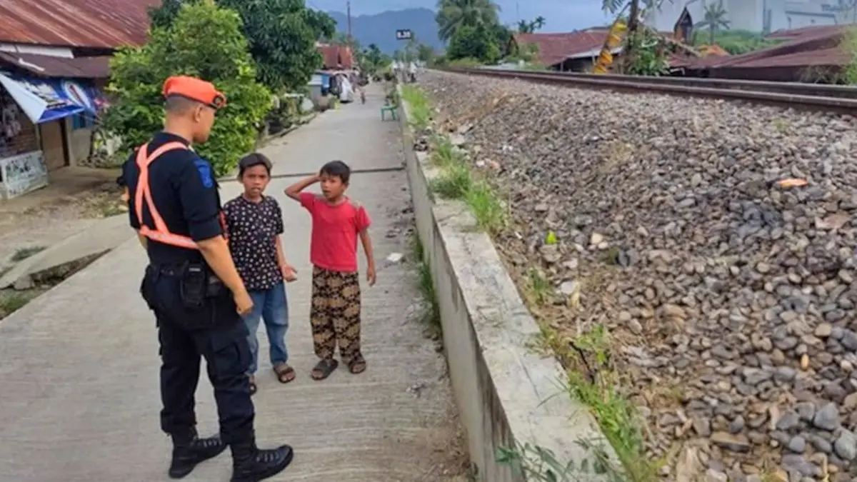 Petugas keamanan KAI memberikan edukasi kepada anak-anak untuk tidak bermain di sekitar perlintasan KA, baru-baru ini. (KAI DIVRE II SUMBAR)