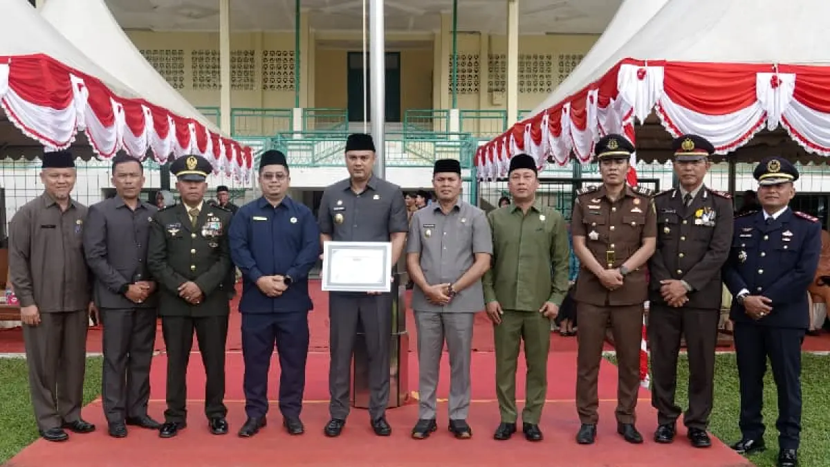 Kepala Loka POM di Kabupaten Sijunjung, Putra Gusrianto menyerahkan Piagam Penghargaan Kabupaten Kota Pangan Aman kepada Bupati Sijunjng, Benny Dwifa Yuswir bertepatan dengan Upacara Hari Pendidikan Nasional di Lapangan M. Yamin Muaro Sijunjung.(Foto: Humas)