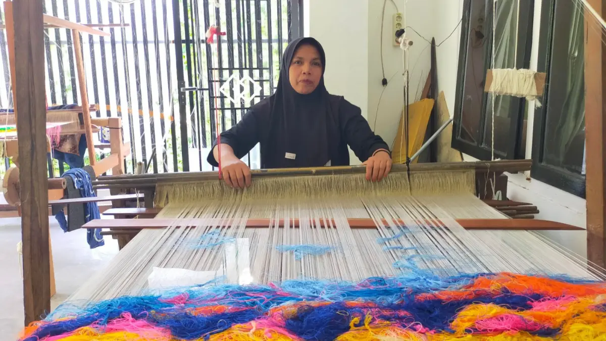 Eltavia menenun songket secara manual di rumahnya di Desa Lunto Timur, Kota Sawahlunto, Sumatera Barat. Ketekunannya menjaga tradisi tenun menjadi penopang ekonomi keluarga dan harapan pendidikan anak-anaknya. (INDRA YOSEF/PADEK)
