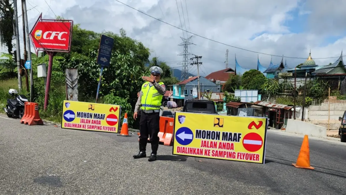 Personel Satlantas Polres Padangpanjang melakukan pengalihan arus jalan lintas Bukittinggi–Padang akibat proyek pengecoran jalan di Simpang MTsN, Kamis (7/5/2026).