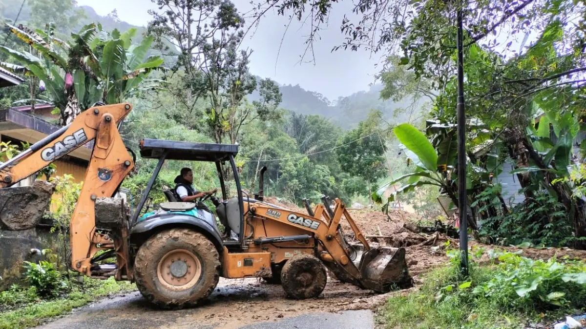 Alat berat milik Dinas BMCKTR Provinsi Sumatera Barat melakukan pembersihan material longsor yang menutup ruas jalan Bukittinggi–Matur di kawasan Sungailandia, Kecamatan Ampekkoto, Jumat (8/5).&nbsp;(DOK BPBD AGAM)