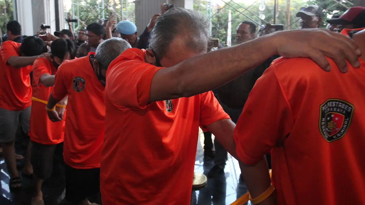 Polisi mengawal sejumlah tersangka kasus joki Ujian Tulis Berbasis Komputer dan Seleksi Nasional Berdasarkan Tes di Polrestabes Surabaya, Kamis (7/5). (DIDIK SUHARTONO/ANTARA FOTO)