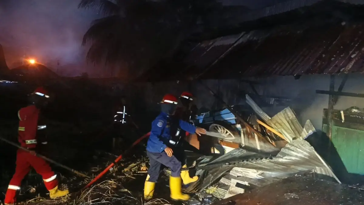 Petugas pemadam kebakaran berusaha memadamkan api yang membakar gudang penyimpanan kayu dan barang bekas di Kelurahan Anduring, Kecamatan Kuranji, Kota Padang, Kamis malam (14/5/2026). (Dinas Damkar Kota Padang)