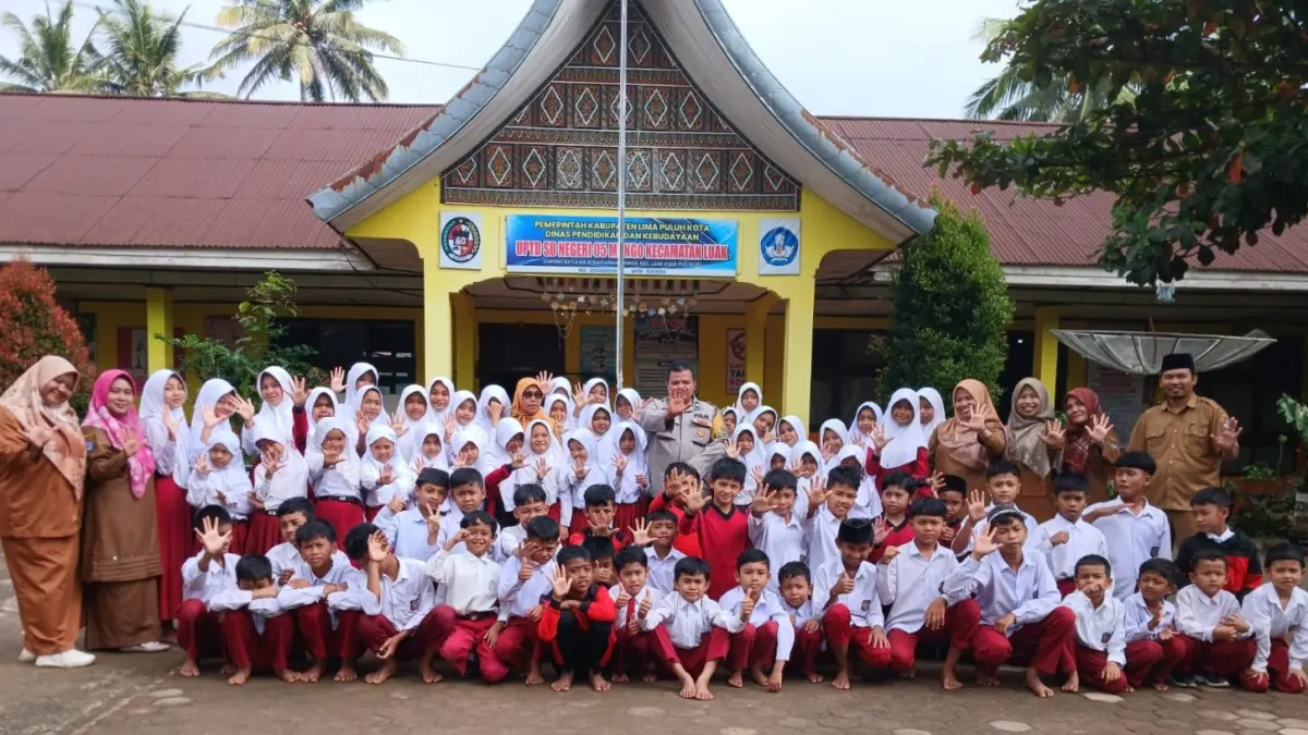 Bhabinkamtibmas dari Polsek Luak, Kabupaten Limapuluh Kota foto bersama murid UPTD SDN 05 Mungo di halaman sekolah beberapa waktu lalu. (TIM LAMAN GURU)