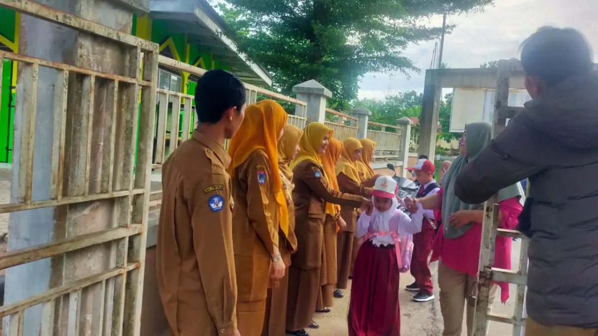 Murid SD Negeri 65 Payakumbuh bersalaman dengan majelis guru sebelum masuk ke ruangan belajar beberapa waktu lalu. (TIM LAMAN GURU)