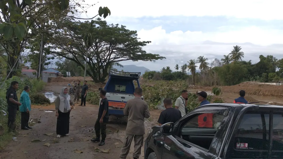 Aparat dari Pemko Padang usai membersihkan pohon tumbang di jalan pinggir sungai kawasan Surau Gadang, Nanggalo, Jumat (22/5/2026),