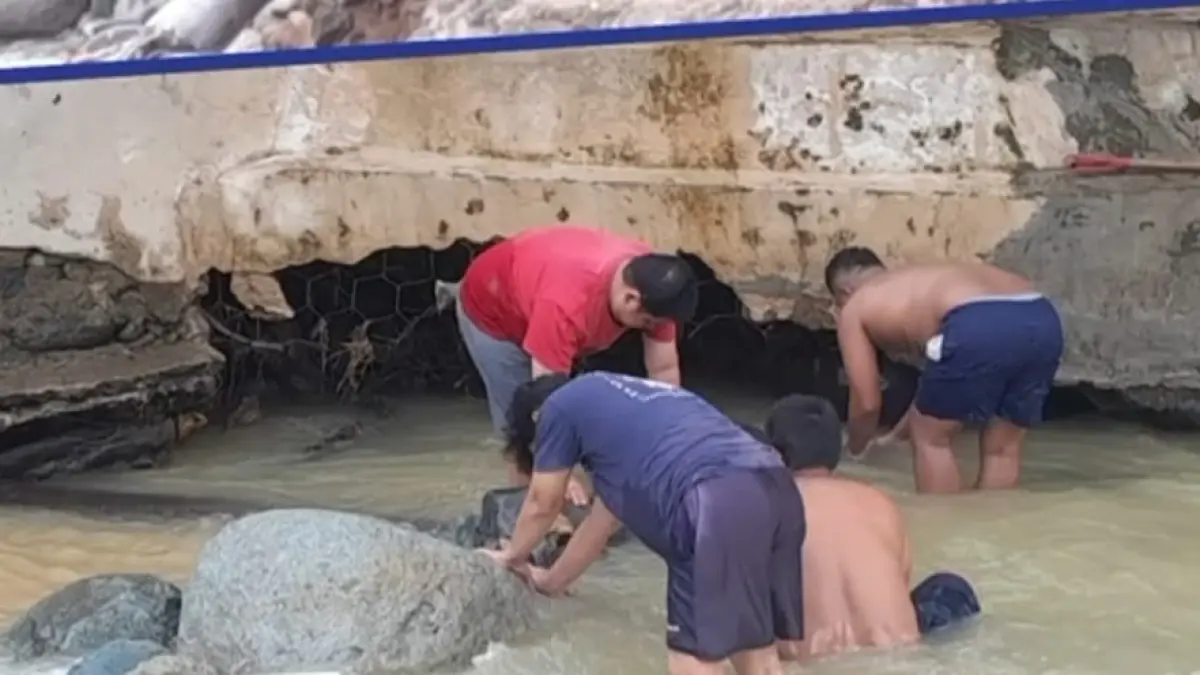Petugas Perumda Air Minum Kota Padang membersihkan itake Guo Jumat pagi (22/5) yang tersumbat lumpur pascaair sungai meluap Kamis (21/5) malam. (Humas Perumda AM Padang)