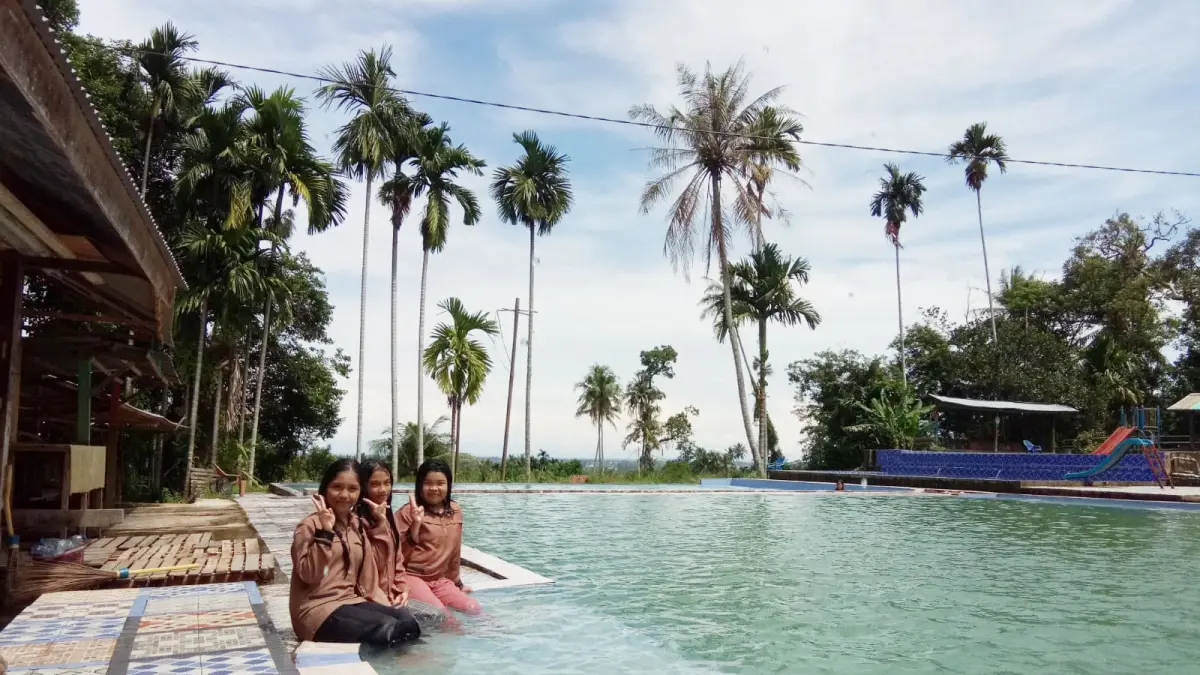 Pengunjung sedang mandi di Kolam Renang Rezky dengan latar pemandangan yang indah. (JUFRI JAO/PADEK)