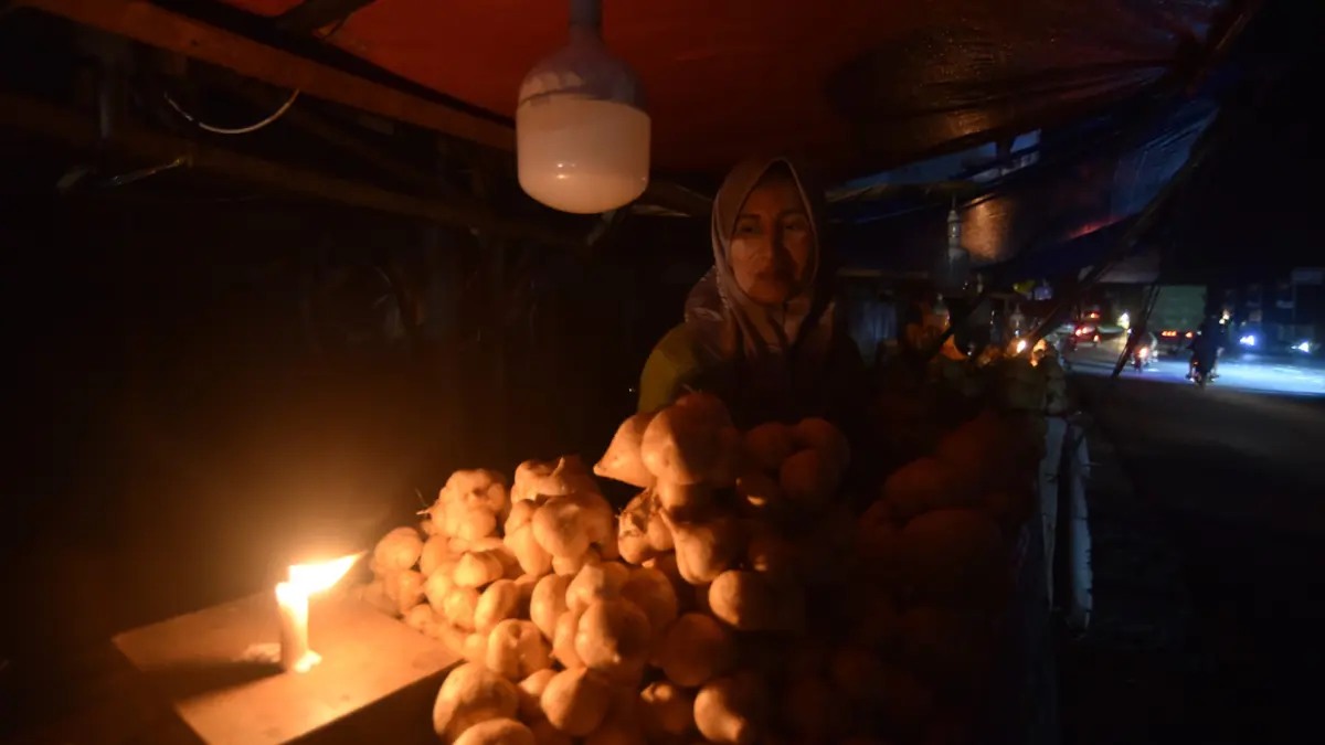Pedagang menggunakan lilin untuk penerang saat listrik padam di Nagari Kasang, Kabupaten Padangpariaman, Sabtu (23/5). Pemadaman listrik massal terjadi di sejumlah daerah di Sumatera sehari sebelumnya. Namun khusus Sumbar, PLN mengklaim, telah kembali normal. (FITRA YOGI /ANTRA FOTO)