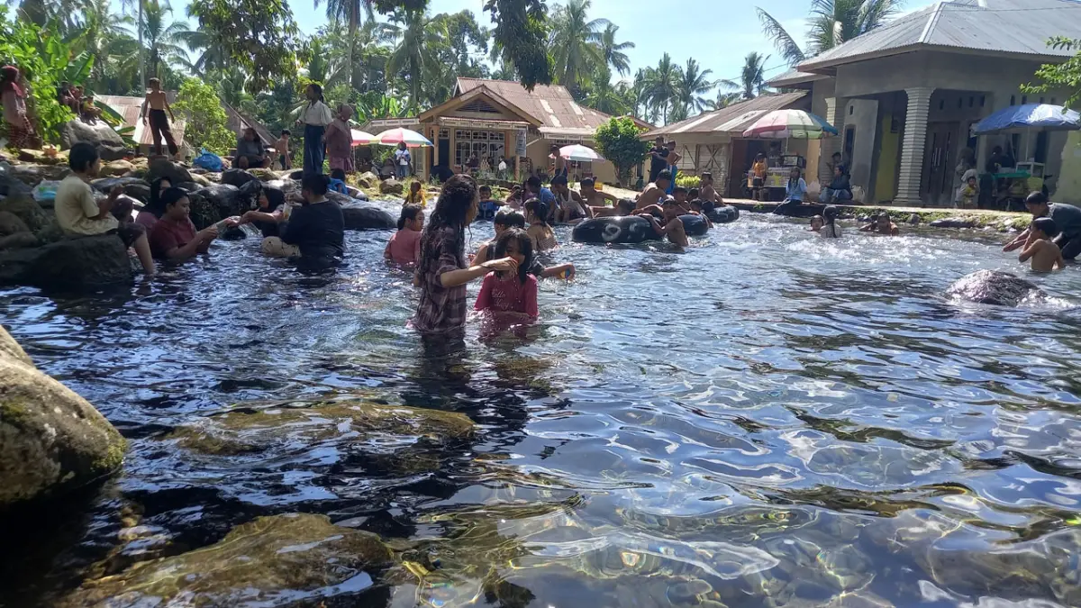 Sejumlah pengunjung bermain di pemandian Sungai Doghe, Minggu (31/6). (ARFIDEL/PADEK)
