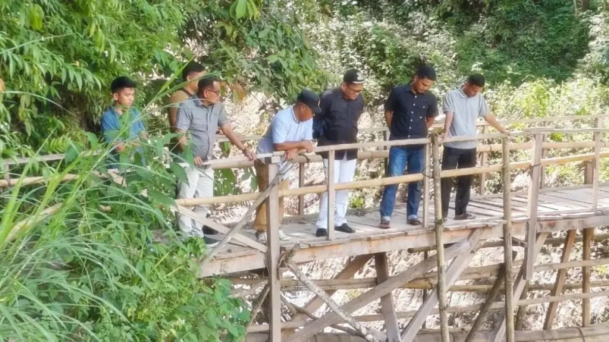 Terlihat Wakil Bupati Pessel, Risnaldi Ibrahim, (dua dari kiri) saat melakukan peninjauan jembatan yang masih dalam bentuk darurat tersebut. (DOK Diskominfo Pessel)