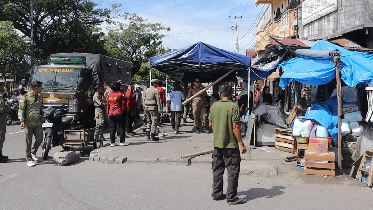 Petugas Satpol PP Kota Padang mengamankan lapak dan perlengkapan pedagang kaki lima yang berjualan di fasilitas umum dan fasilitas sosial di Kecamatan Koto Tangah, Rabu (3/6/2026).