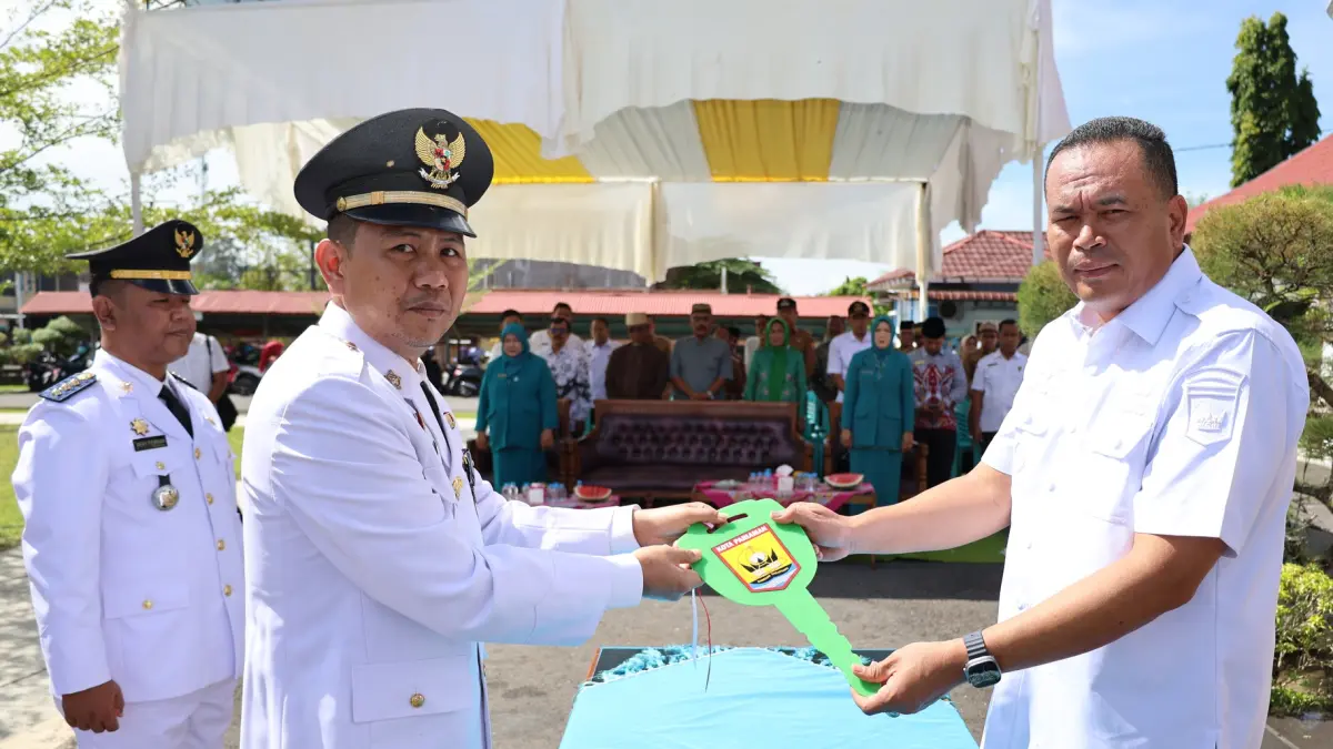 Wali Kota Pariaman, Yota Balad (kiri), menyerahkan simbolis kunci mobil dinas kepada Hery Febrian saat serah terima jabatan Camat Pariaman Selatan di halaman Kantor Camat Pariaman Selatan, Kota Pariaman, Rabu (3/6/2026).