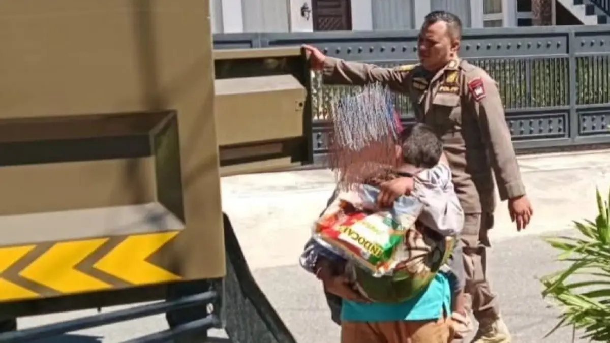 Personel Satpol PP Kota Padang mengamankan perempuan yang mengemis dengan membawa anak di lampu merah Jalan Imam Bonjol, Kamis (4/6/2026). (Humas Satpol PP Padang)