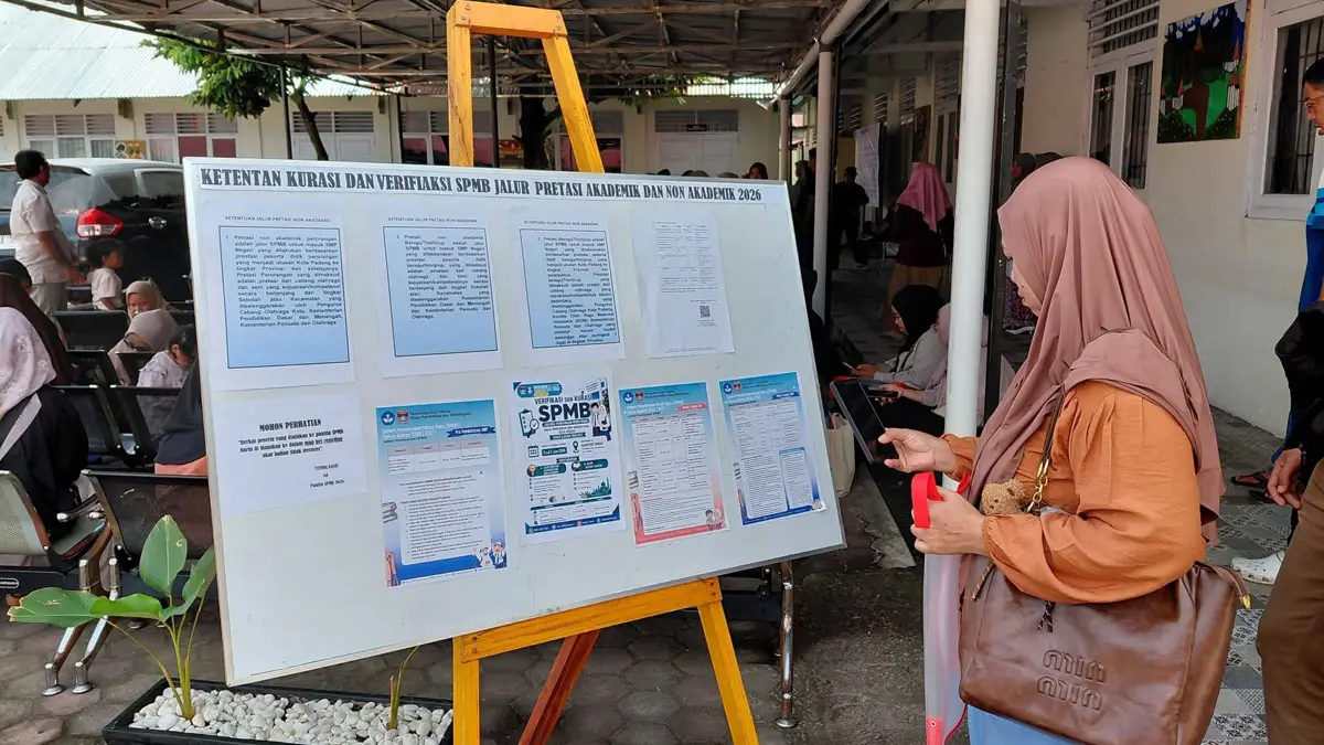 Salah seorang calon wali murid sedang melihat informasi pendaftaran SPMB beberapa waktu. (DOK DISKOMINFO PADANG)