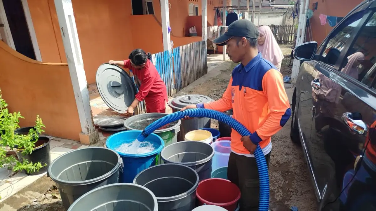 Petugas BPBD dan Damkar Padang saat mendistribusikan air bersih kepada warga terdampak bencana banjir bandang, Sabtu (6/6/2026). (BPBD Padang)