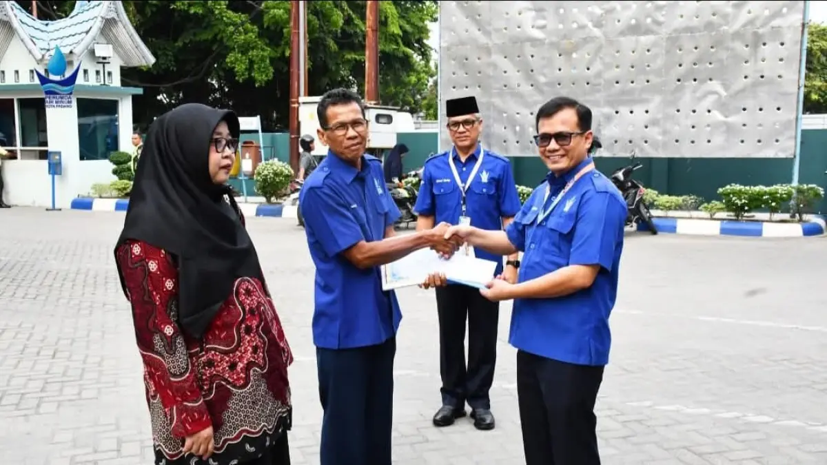 Direktur Teknik Perumda Air Minum Kota Padang Andri Satria didampingi Dirum Afrizal Kuning menyerahkan piagam penghargaan kepada karyawan yang purnabakti saat upacara bendera Senin (8/6) di kantor pusat Perumda AM Padang. (DOKUMENTASI PERUMDA AM PADANG)