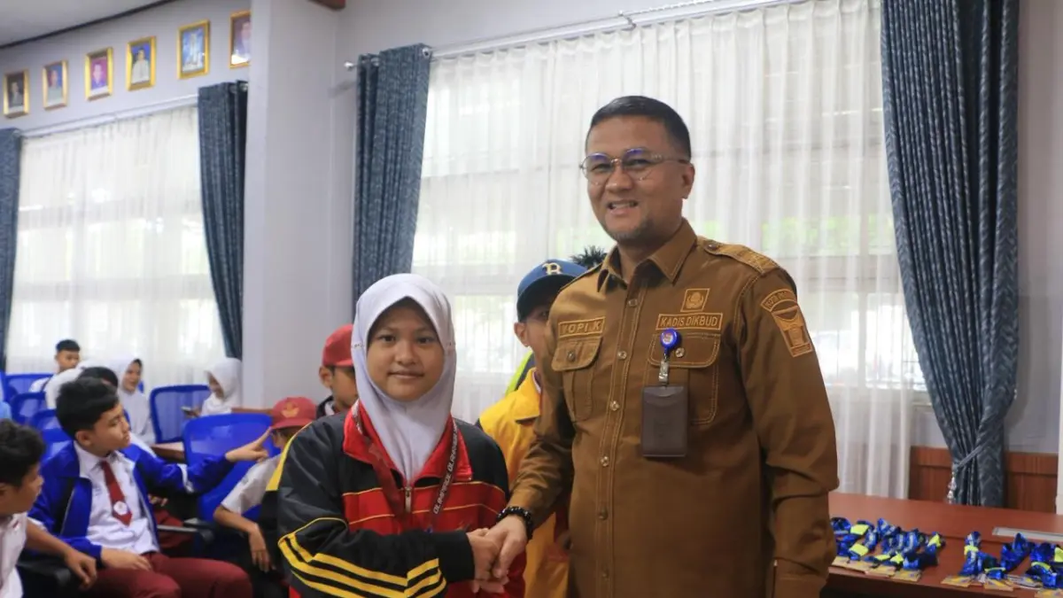Siswi SDN 45  Bungo Pasang, Hooriya Fetrina bersalaman dengan Kepala Dinas Pendidikan Kota Padang, Yopi Krislova, SH., MM di ajang O2SN 2026 beberapa waktu lalu. (TIM LAMAN GURU)