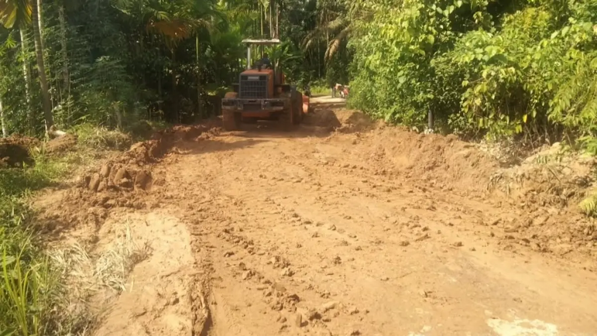 Petugas Dinas PUTR Kabupaten Agam membersihkan material tanah dan bebatuan yang menutup akses jalan Simpang BK–Koto Alam di kawasan Sitanang Kaciak, Nagari Batu Kambing, Rabu (17/6/2026). 