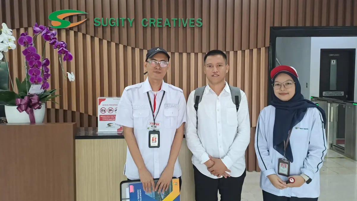 Penyandang disabilitas asal Lubukbasung, Rori Rafia Dinata (tengah), berfoto bersama petugas pendamping di lobi PT Sugity Creatives Cikarang, Jawa Barat, pada hari pertama bekerja, Rabu (17/6). 