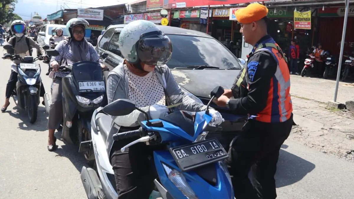 Petugas KAI Divre II Sumbar memberikan edukasi keselamatan kepada pengguna jalan di perlintasan sebidang kereta api di Kota Padang, Rabu (17/6/2026).