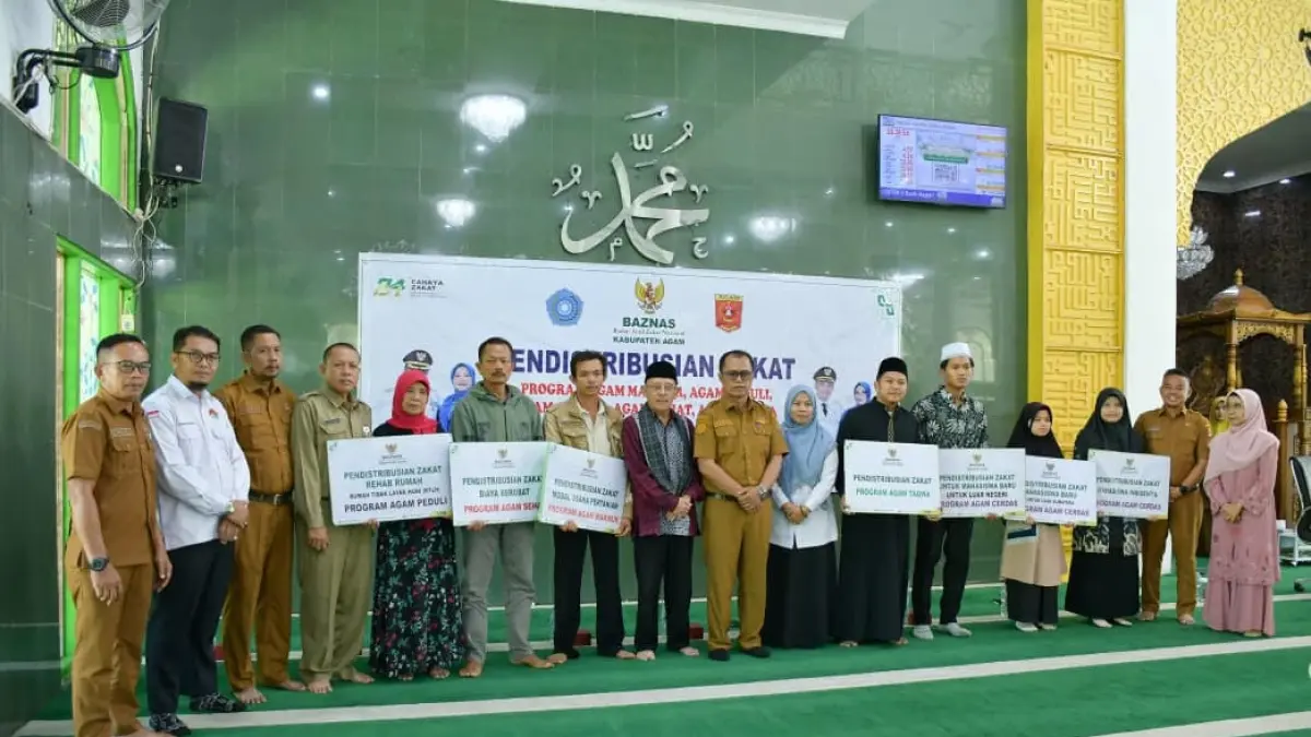 Staf Ahli Bidang SDM Setdakab Agam, Taslim, bersama jajaran Baznas Agam dan para penerima manfaat usai penyerahan zakat periode Juni 2026 di Masjid Agung Nurul Falah Lubukbasung, Senin (22/6). (DOK PEMKAB AGAM)